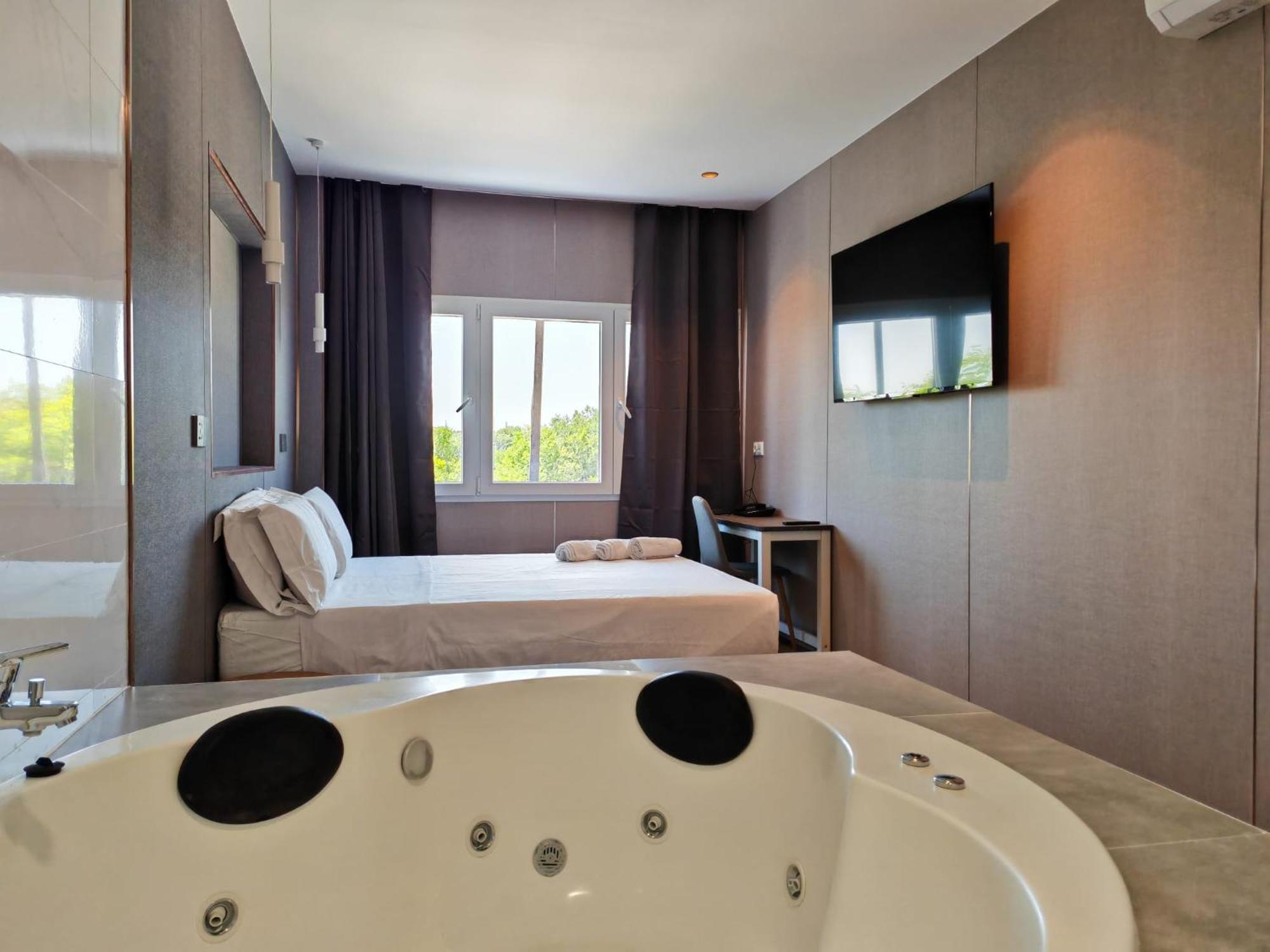 Habitación con cama grande y bañera de hidromasaje