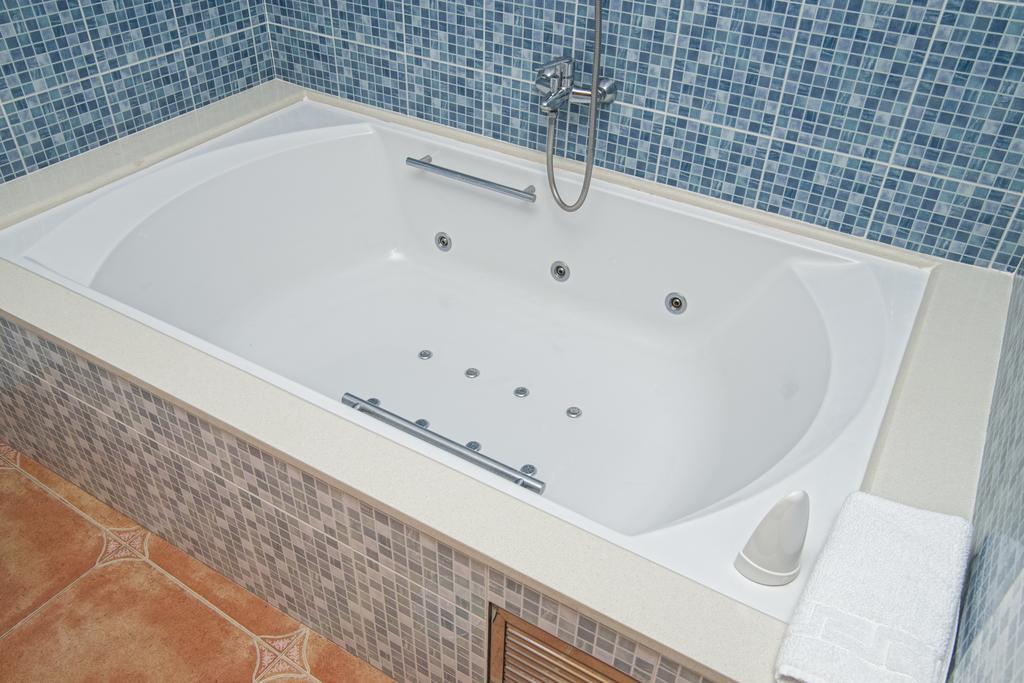 Habitación con cama grande y bañera de hidromasaje